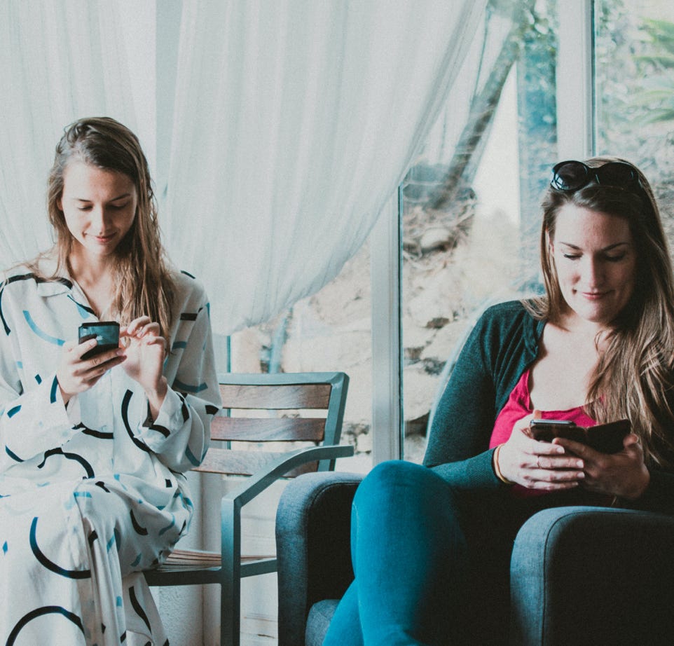 Two Women Using Smartphones Inside Room to talk about Doug